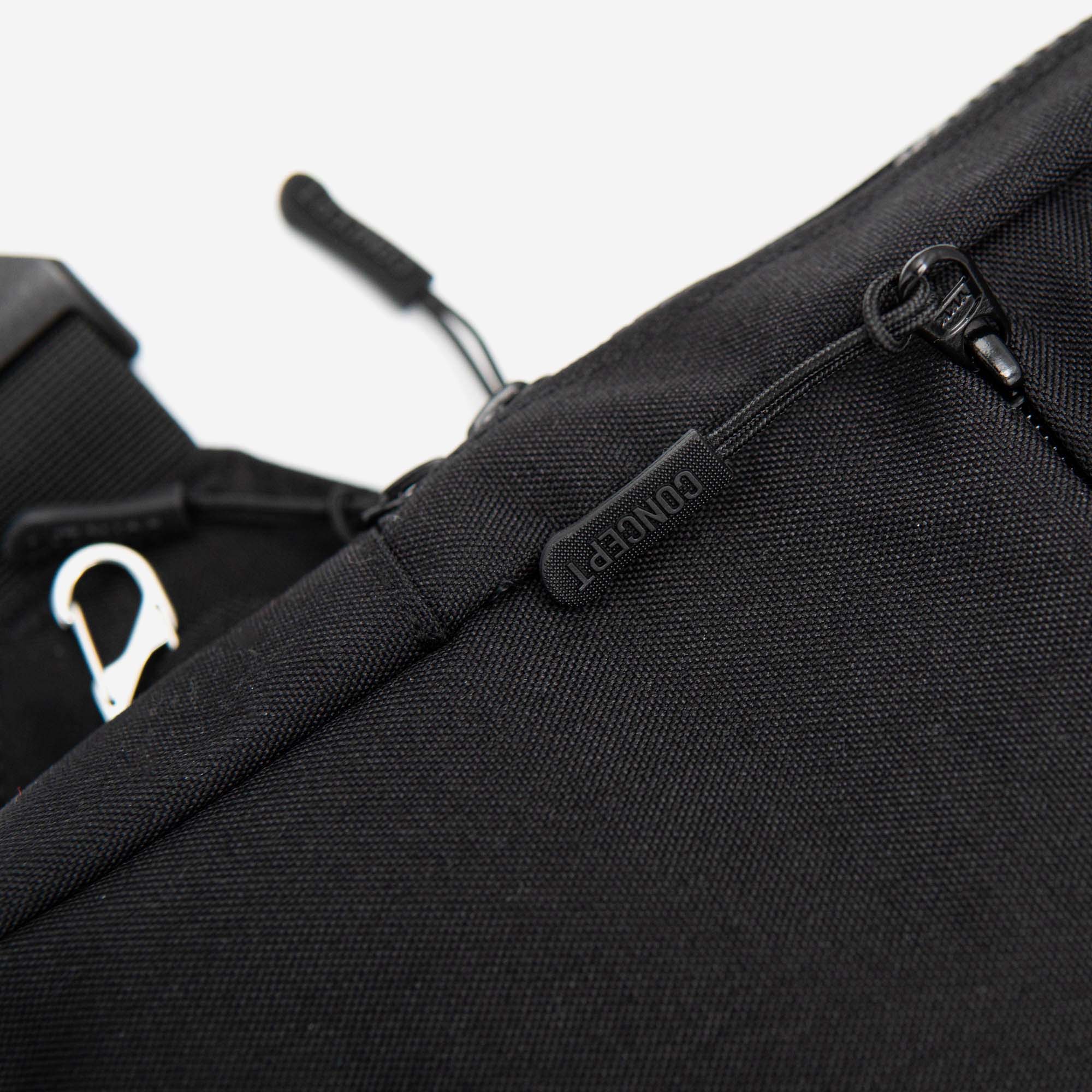 Close-up of a black backpack with a visible brand logo on a white background